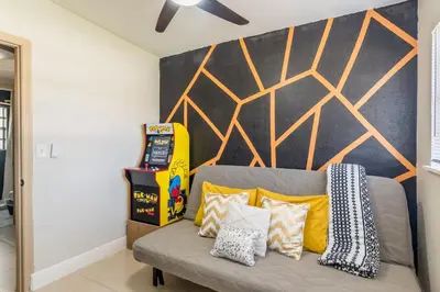 a living room with a couch with pillows on it at Jacuzzi and Games Close to Dwtn Disney and Parks in Orlando