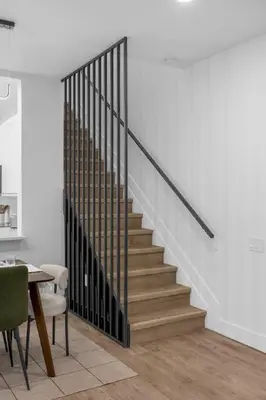 a staircase in a living room with a table and chairs at Modern Winter Park Townhome in Prime Location in Orlando