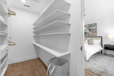 a white bedroom with white shelves and a bed at Modern Winter Park Townhome in Prime Location in Orlando