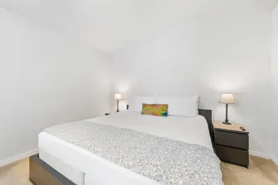 a bedroom with a large white bed and two lamps at 2730 Club Cortile Circle Apt. B in Kissimmee
