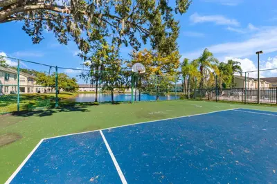 a tennis court with a basketball hoop on it at 2730 Club Cortile Circle Apt. B in Kissimmee