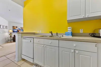 a kitchen with a sink and a yellow wall at 2730 Club Cortile Circle Apt. B in Kissimmee