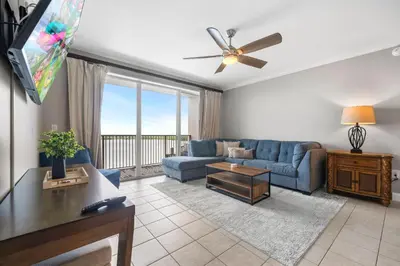 a living room with a blue couch and a tv at 13415 Blue Heron Beach Dr 1-708 in Orlando