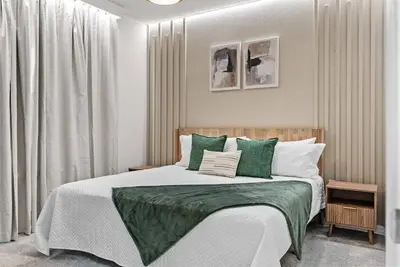 a bedroom with a bed with green and white pillows at Brand New 05 Bedrooms At Windsor Cay in Orlando