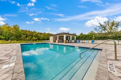 a swimming pool with a house in the background at 4461 Summer Flowers Pl in Kissimmee