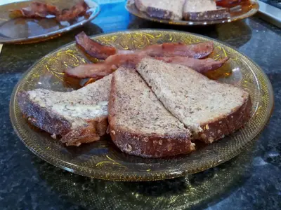 a plate with two slices of bread and bacon at Kapp and Kappy Bed & Breakfast in Kissimmee