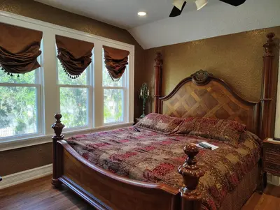 a bedroom with a large bed with a wooden bed frame at Kapp and Kappy Bed & Breakfast in Kissimmee