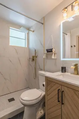 a bathroom with a toilet and a sink and a mirror at CUTE and COZY studio w jacuzzi in Orlando