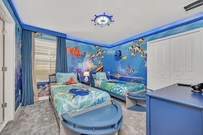 a childrens room with two beds and a blue wall at Mahuna Matata in Kissimmee