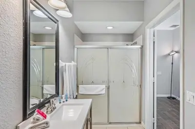 a bathroom with a sink and a shower and a mirror at Townhouse Moderna no Vista Cay in Orlando
