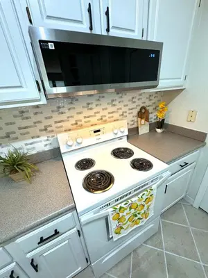 a kitchen with a stove and a microwave at Wonderful apt remodeled in November near Disney in Kissimmee