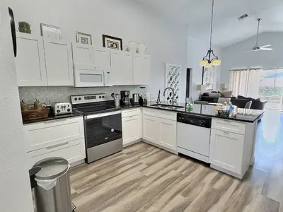 a kitchen with white cabinets and white appliances at Casa 4Q c/ Piscina Aquecida — Lake Berkley in Kissimmee