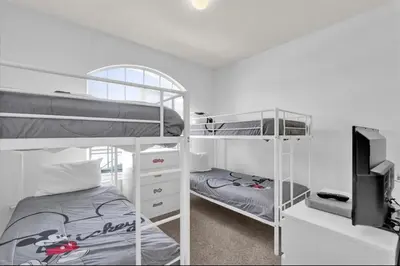 a bedroom with two bunk beds and a tv at Mickeys Villa in Kissimmee