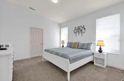 a white bedroom with a bed and a window at Mickeys Villa in Kissimmee
