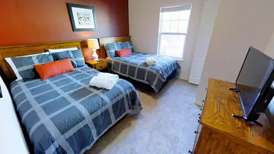 a bedroom with two beds and a flat screen tv at Cozy 3 BD Townhome 2 king beds Close to Disney 1503 in Kissimmee