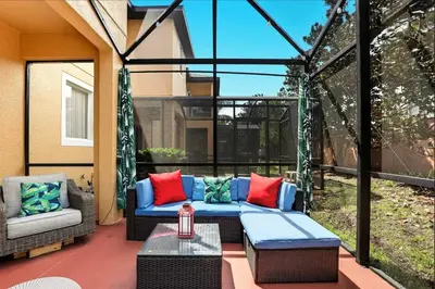 a patio with a couch and a table and chairs at Park Hopper Paradise At Regal Oaks in Orlando