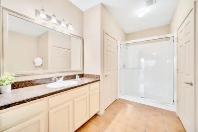 a bathroom with a sink and a mirror at Family Fun Condo Pool and Sauna near Disney in Orlando