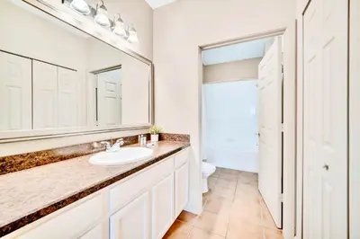 a bathroom with a sink and a mirror at Family Fun Condo Pool and Sauna near Disney in Orlando