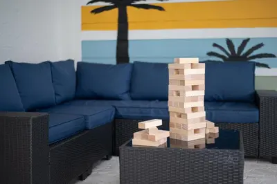 a living room with a blue couch and a wooden block tower at Entire Home with Pool, Ping Pong Table and Arcade games in Kissimmee