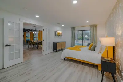 a bedroom with a large bed and a living room at Entire Home with Pool, Ping Pong Table and Arcade games in Kissimmee