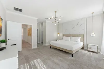 a white bedroom with a bed and a white wall at 4350 Storey Lake 17 guests near parks poolspa in Kissimmee