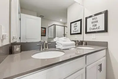 a bathroom with a sink with two mirrors and towels at New Storey Lake Dream Family Escape in Kissimmee