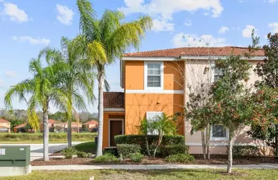 a house with palm trees in front of it at Family Home 20 min Disney 4BR Heated Pool BBQ in Kissimmee