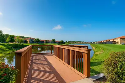 a wooden bridge over a river in a yard at Family Home 20 min Disney 4BR Heated Pool BBQ in Kissimmee