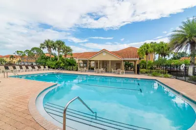 a swimming pool with chairs and a house at Magic Home! GREAT Spot - 15Min Disney20 Universal in Kissimmee