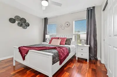 a bedroom with a white bed with red pillows at Magic Home! GREAT Spot - 15Min Disney20 Universal in Kissimmee