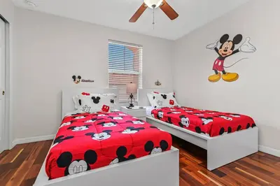 a bedroom with two beds and a mickey mouse bedspread at Magic Home! GREAT Spot - 15Min Disney20 Universal in Kissimmee