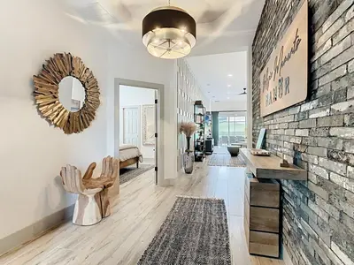 a living room with a stone wall and a mirror at 4BR Luxury Villa, Pool & GameRoom in Windsor Hills in Orlando