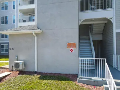 a building with a staircase and a sign on it at Themed 2BR Condo Near Disney + Resort Amenities in Kissimmee