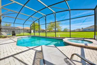 an indoor swimming pool with a clear glass roof at Ohana Haven home in Orlando