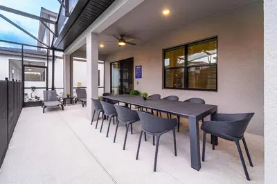 a dining room with a black table and chairs at Mansão 8Q Disney c/ Cinema, Game Room, Piscina in Orlando