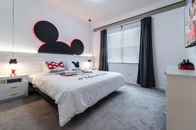 a bedroom with a large white bed and a window at Mansão 8Q Disney c/ Cinema, Game Room, Piscina in Orlando