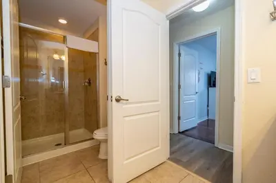 a bathroom with a toilet and a glass shower at Paradise Palms - Spacious house and swimming pool in Kissimmee
