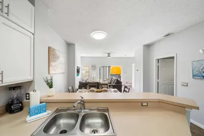 a kitchen with a sink and a living room at 4704 Flagler Beach Way in Kissimmee