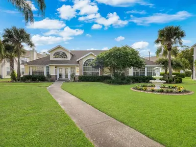 a large house with a lawn and a fountain at 5005 Laguna Bay Cir 18 in Kissimmee