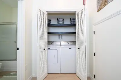 a kitchen with white cabinets and a washer and dryer at Cozy 4 BR close to Disney in Kissimmee