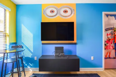 a room with a blue wall with a flat screen tv at 3 Bedroom 8 Miles from Disney Word in Kissimmee