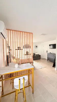 a dining room with a table and a living room at Hermoso apartaestudio en Orlando in Orlando