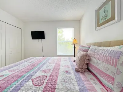 a bedroom with a bed with a pink and white blanket at Endless Summer home in Kissimmee