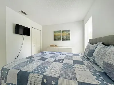 a bedroom with a blue and white quilt on a bed at Endless Summer home in Kissimmee