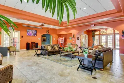 a large living room with orange walls and furniture at Oakwater Lookout condo in Orlando