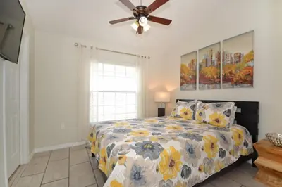a bedroom with a bed and a ceiling fan at Villa Tropics villa in Orlando
