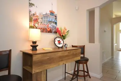 a room with a desk with a clock and a painting at Villa Tropics villa in Orlando