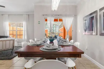 a dining room with a wooden table and white chairs at Paradise 4Bd w Private Pool & Waterpark 8951 in Kissimmee