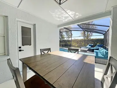 a dining room with a wooden table and a patio at Magical Dreams home in Kissimmee