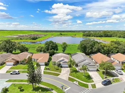 an aerial view of a community of houses with a lake at Magical Dreams home in Kissimmee